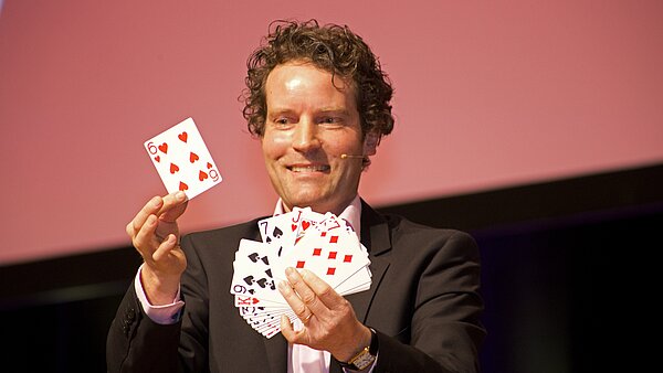 Ein Zauberer mit Spielkarten in der Hand