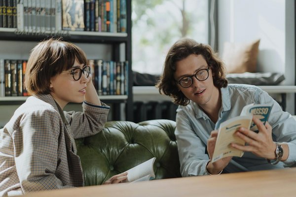 zwei Personen mit Büchern im Gespräch
