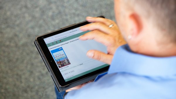 ein Mann verwendet die Onleihe am Tablet
