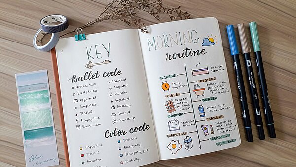 Bullet Journal mit Stiften und Washi Tapes
